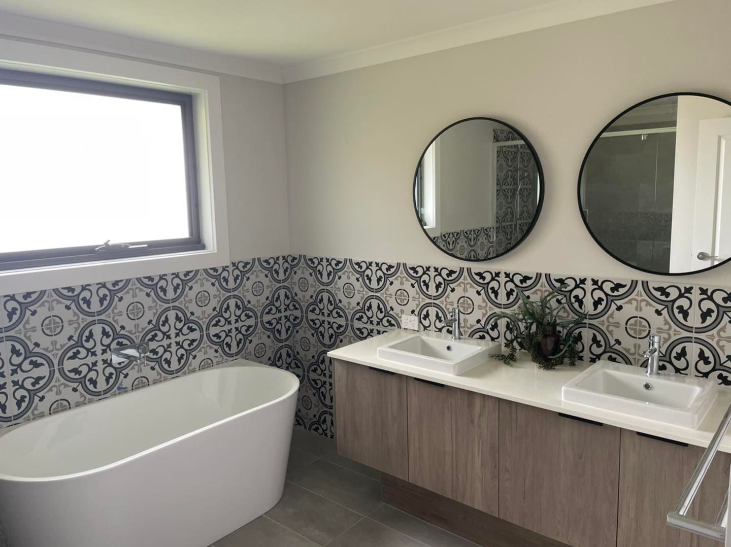 A Bathroom With a Tub , Sink , Shower and Mirror — Evoke Building Group In Ballarat Central, VIC