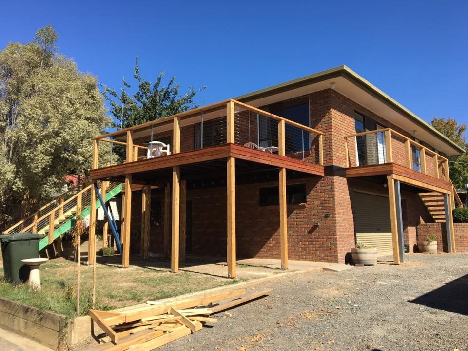 A Large Brick House With a Wooden Deck and Stairs — Evoke Building Group In Ballarat Central, VIC