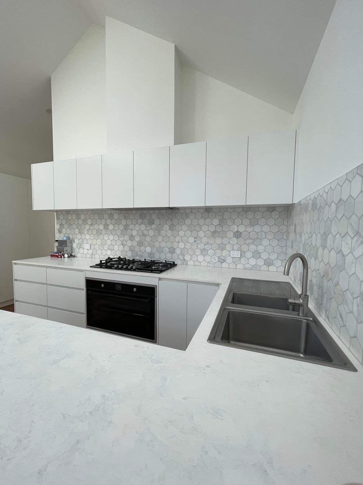 A Kitchen With White Cabinets, a Stove and a Sink — Evoke Building Group In Ballarat Central, VIC