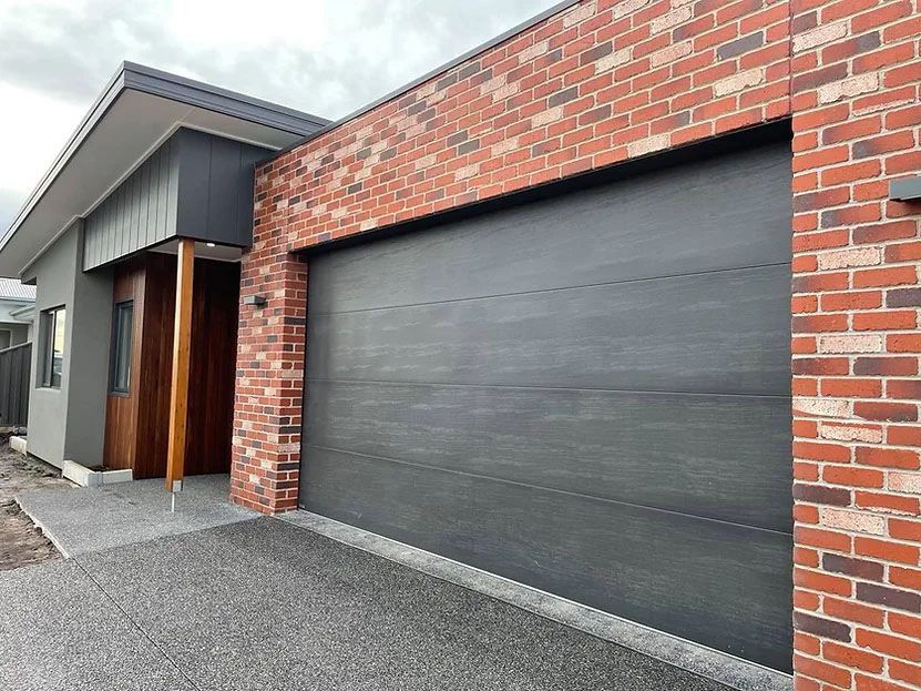A Brick House With a Black Garage Door and a Black Garage Door — Evoke Building Group In Ballarat Central, VIC