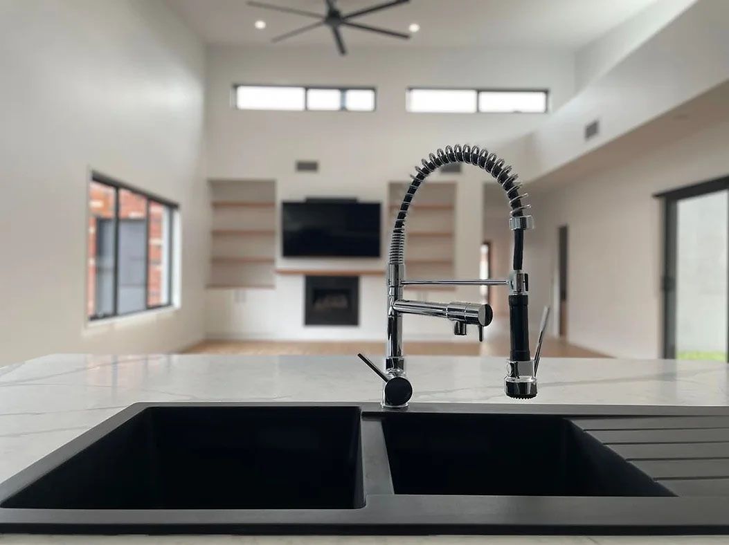A Kitchen Sink With a Faucet and a Television in the Background — Evoke Building Group In Ballarat Central, VIC