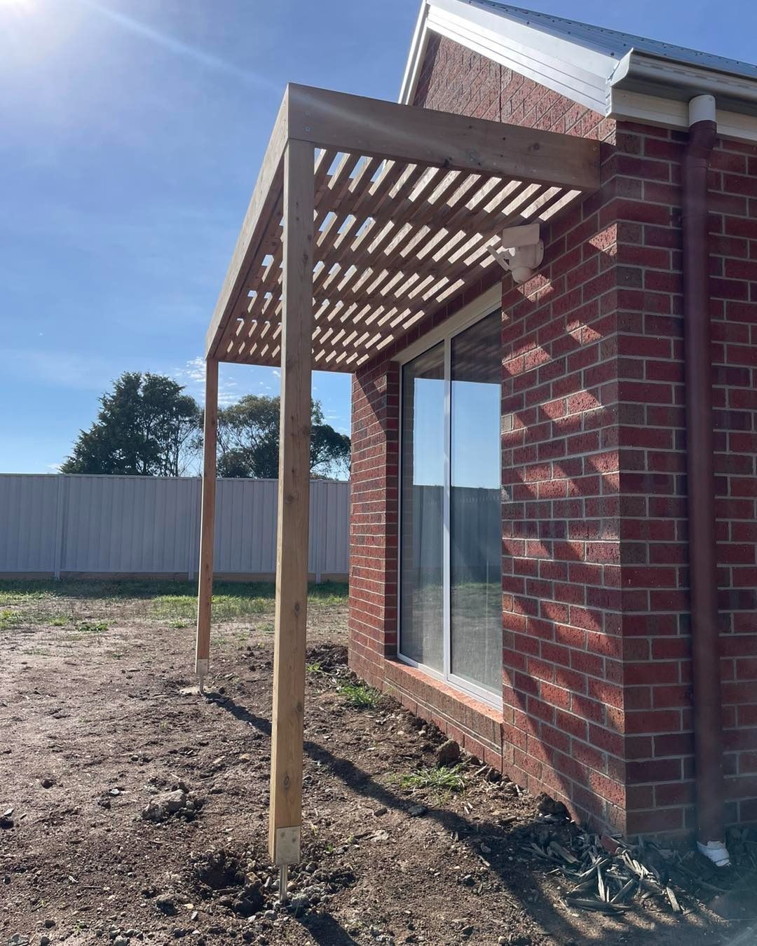 Red Brick House With A Wooden Pergola