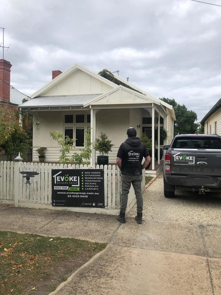 A Man is Standing in Front of a House With a Truck Parked in Front of It — Evoke Building Group In Ballarat Central, VIC