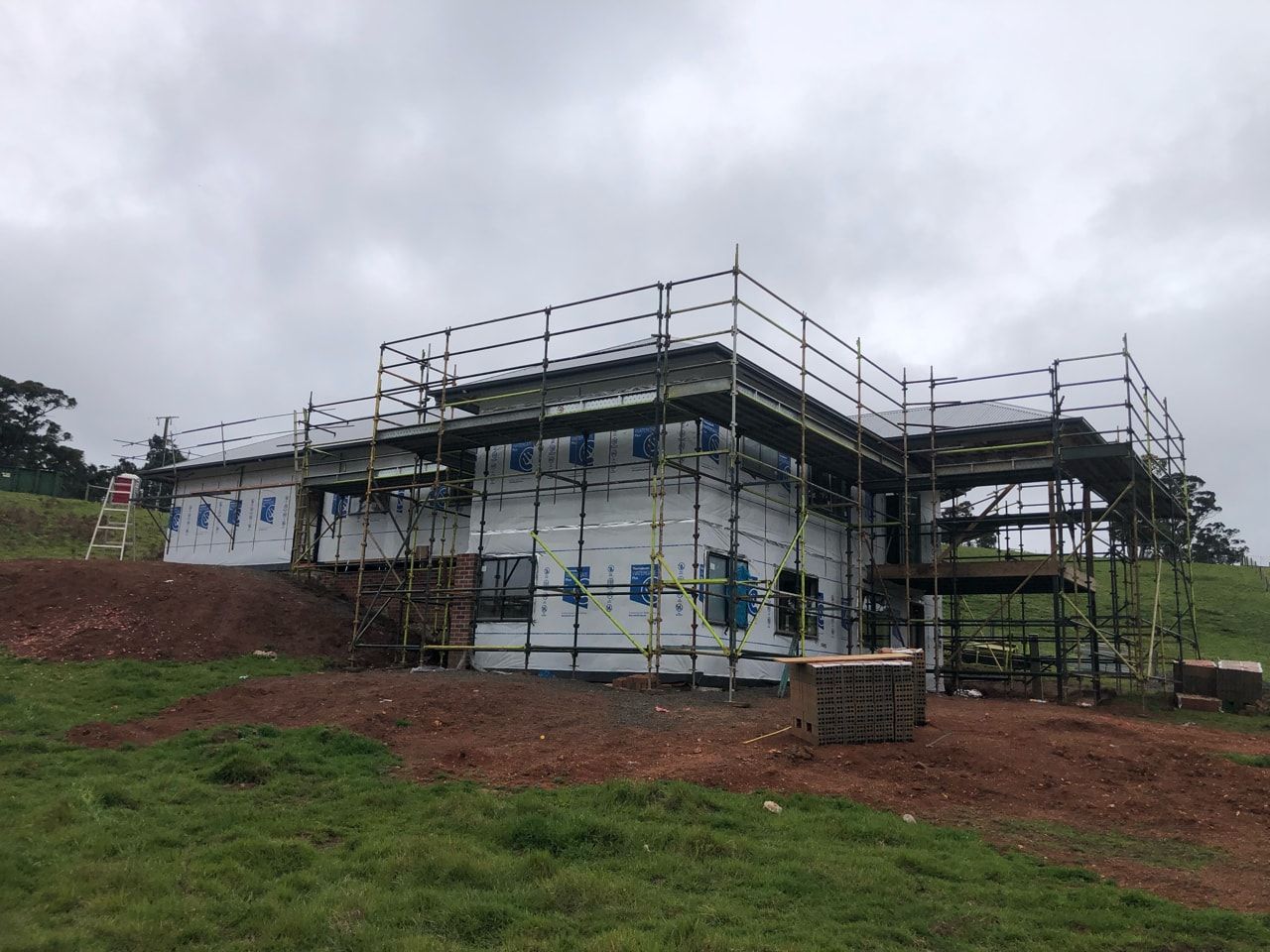 A Brick House With a Wooden Porch and Chairs — Evoke Building Group In Ballarat Central, VIC