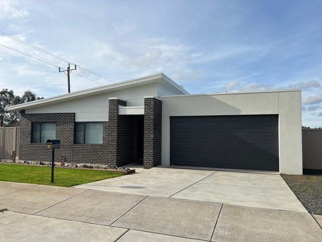 A White House With a Black Garage Door and a Mailbox in Front of It — Evoke Building Group In Ballarat Central, VIC