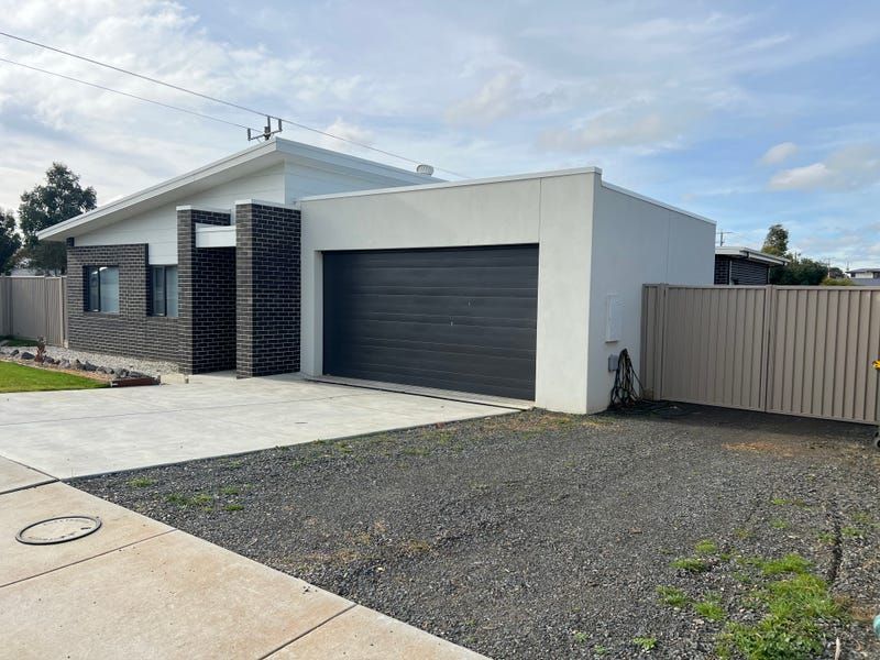 A White House With a Garage and a Fence in Front of It — Evoke Building Group In Ballarat Central, VIC
