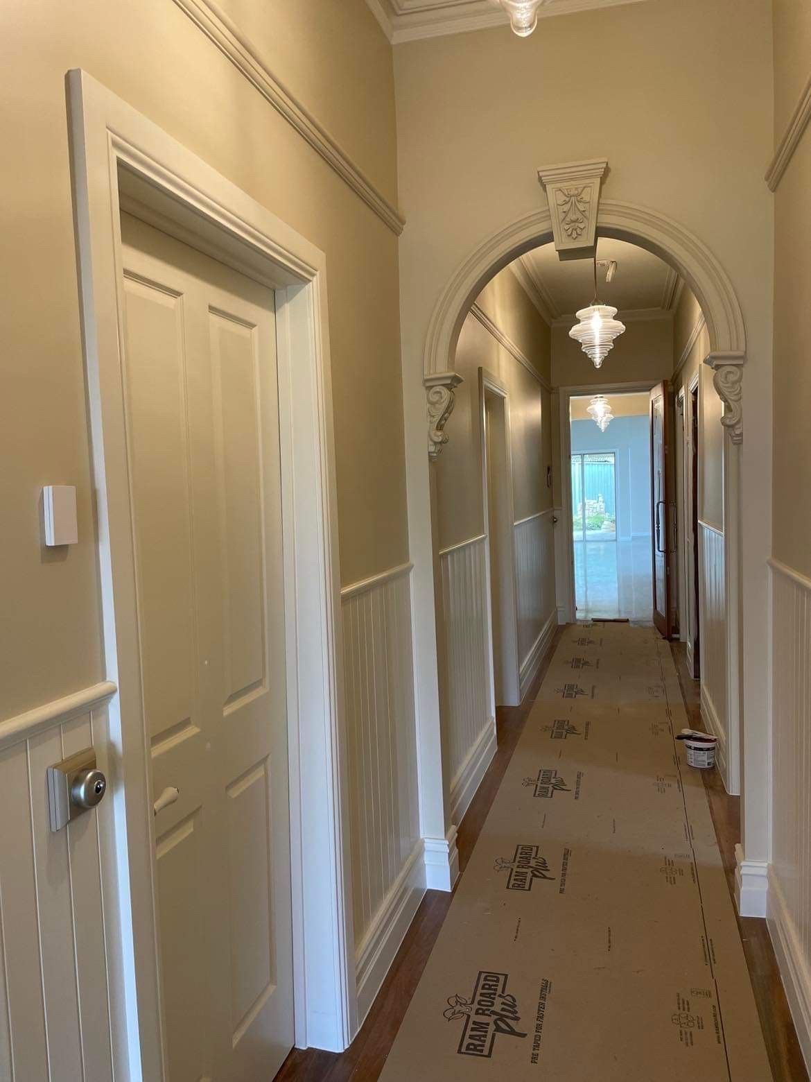 A Long Hallway With a Rug on the Floor and a Doorway Leading to a Room — Evoke Building Group In Ballarat Central, VIC
