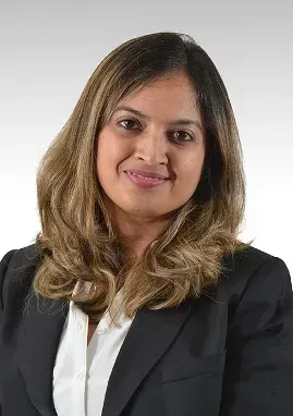 A woman in a black jacket and white shirt is smiling for the camera.
