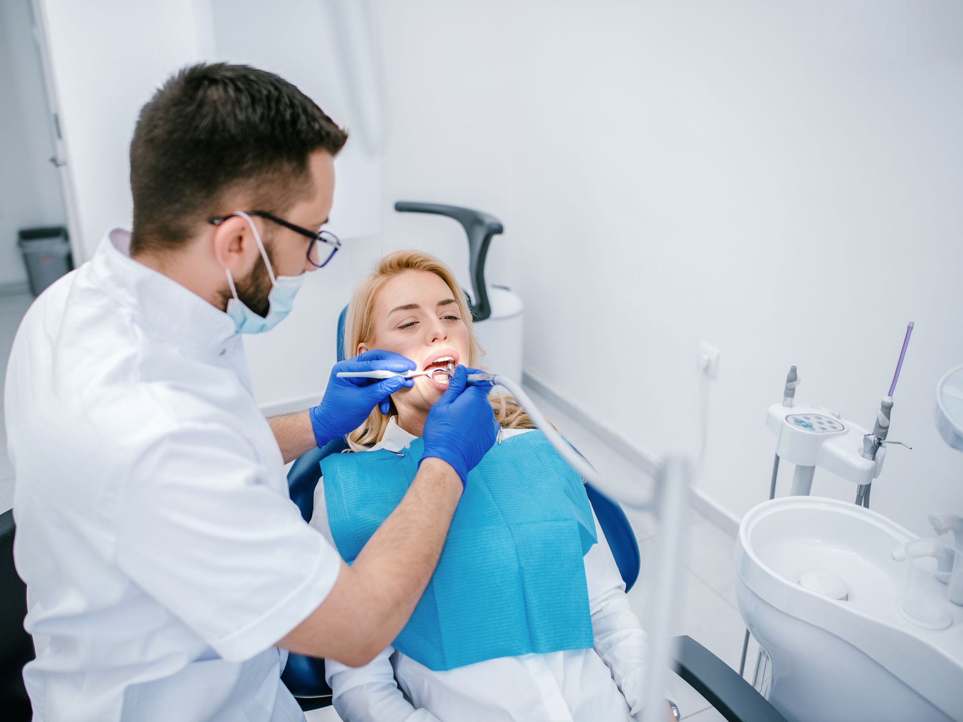 A dentist examining a patient’s teeth in an office, showcasing the expertise of periodontists.