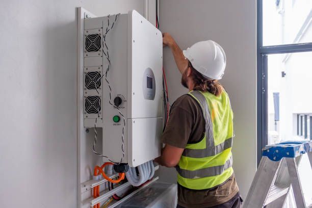 A man is installing a solar panel on a wall.