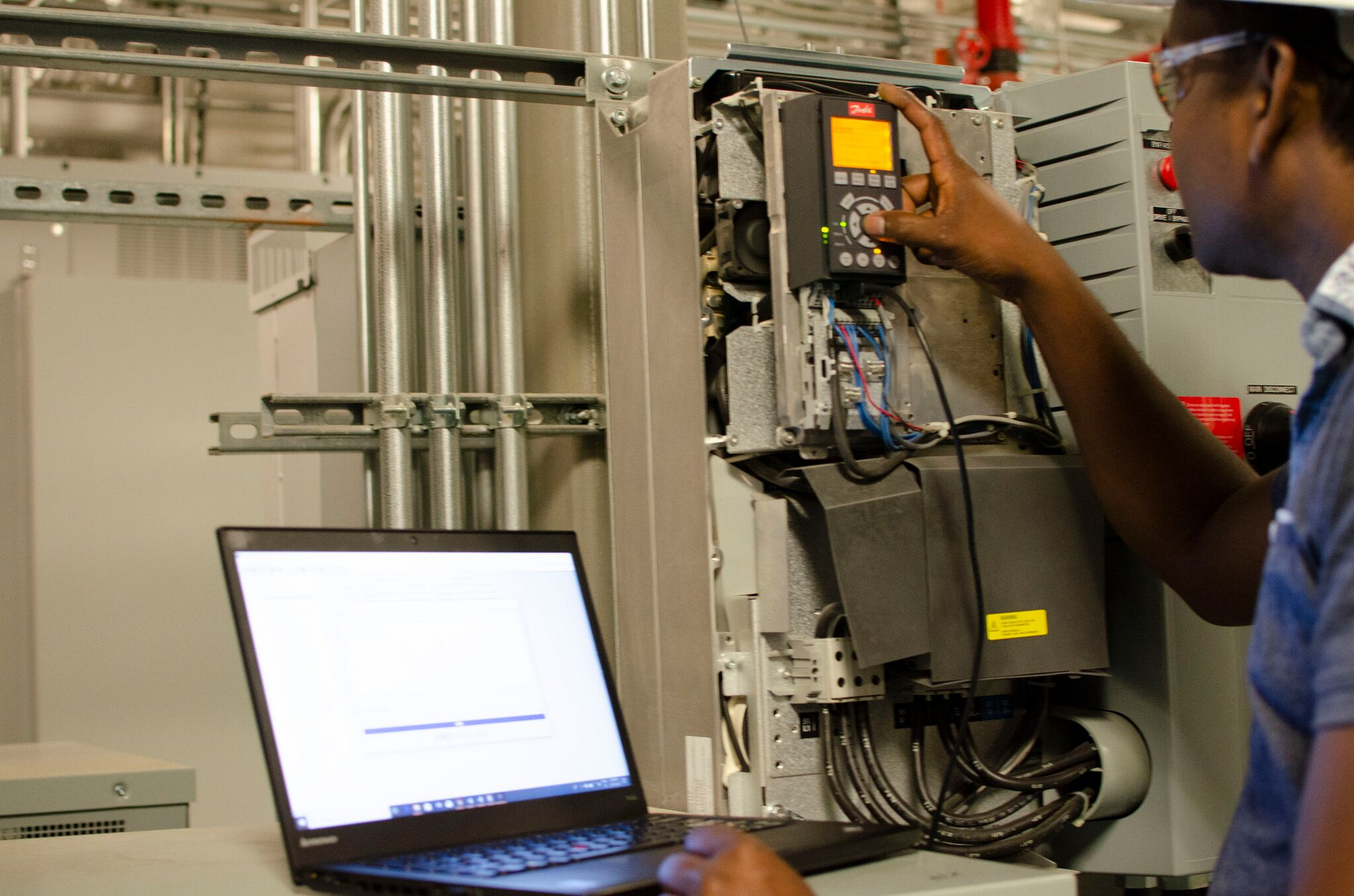 A man and a woman are working on a machine in a factory.