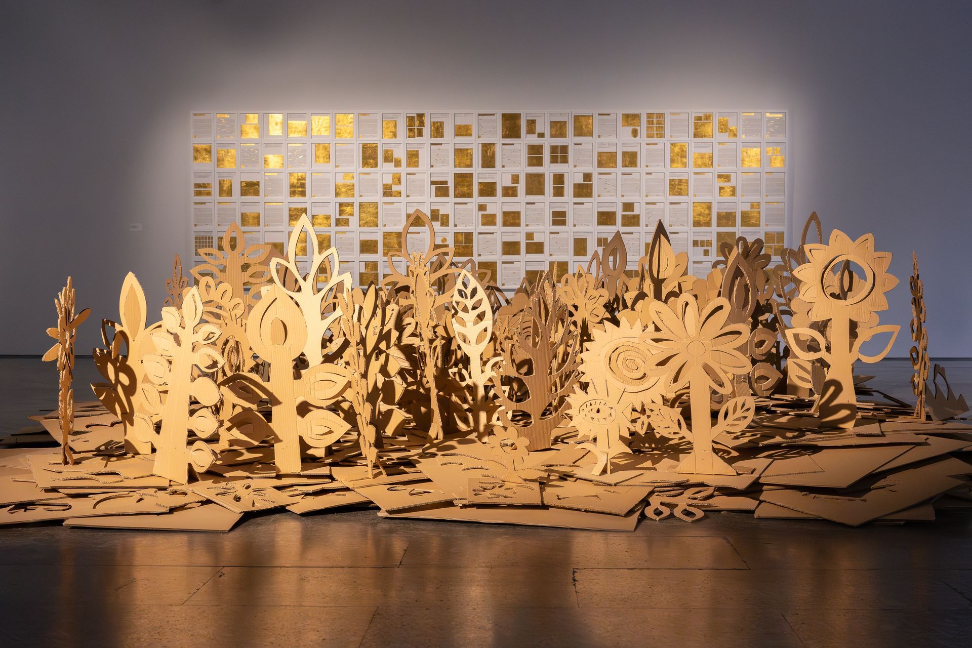 Una escultura hecha de cartón está sentada en el suelo de una habitación.