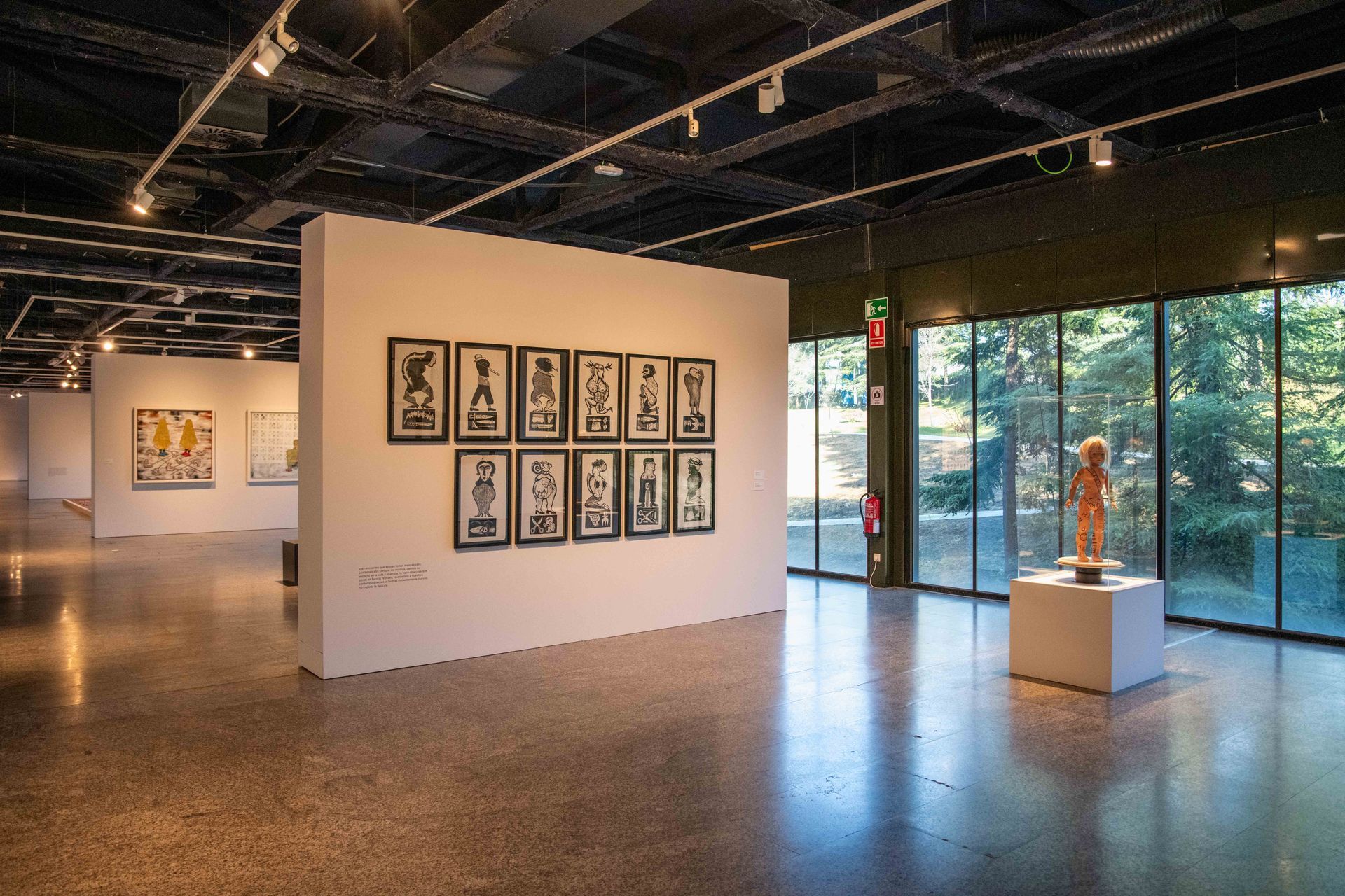 Una habitación grande con muchas ventanas y cuadros en las paredes.