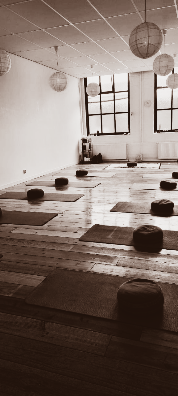 Yogastudio met matten, kussens en papieren lantaarns.