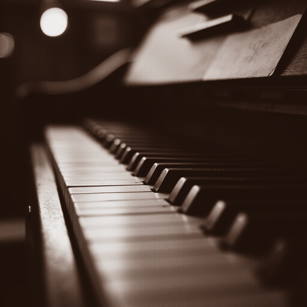 Close-up van pianotoetsen, met een lessenaar op de achtergrond, in sepiatint.