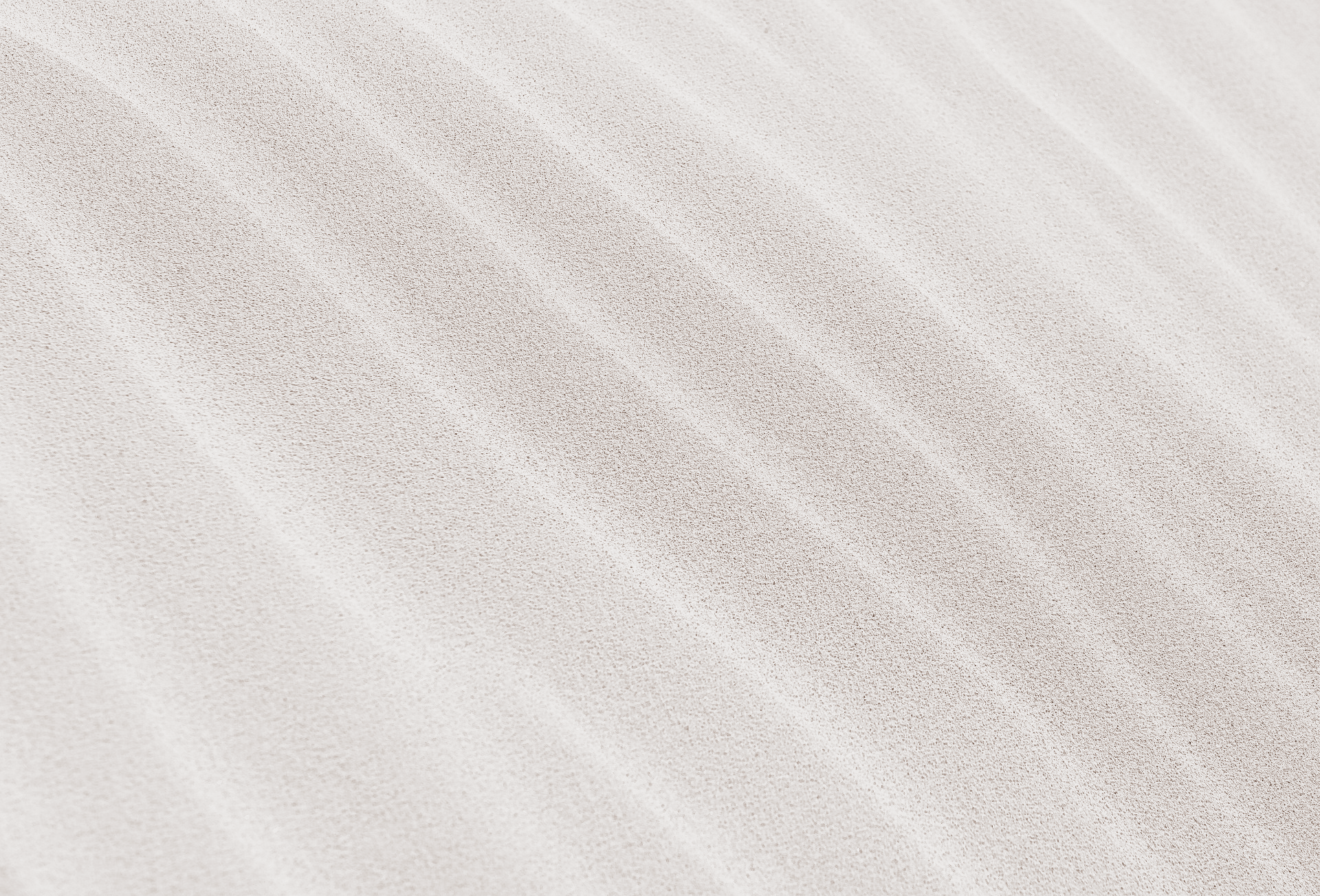 Witte zandduinen met een golvende structuur.