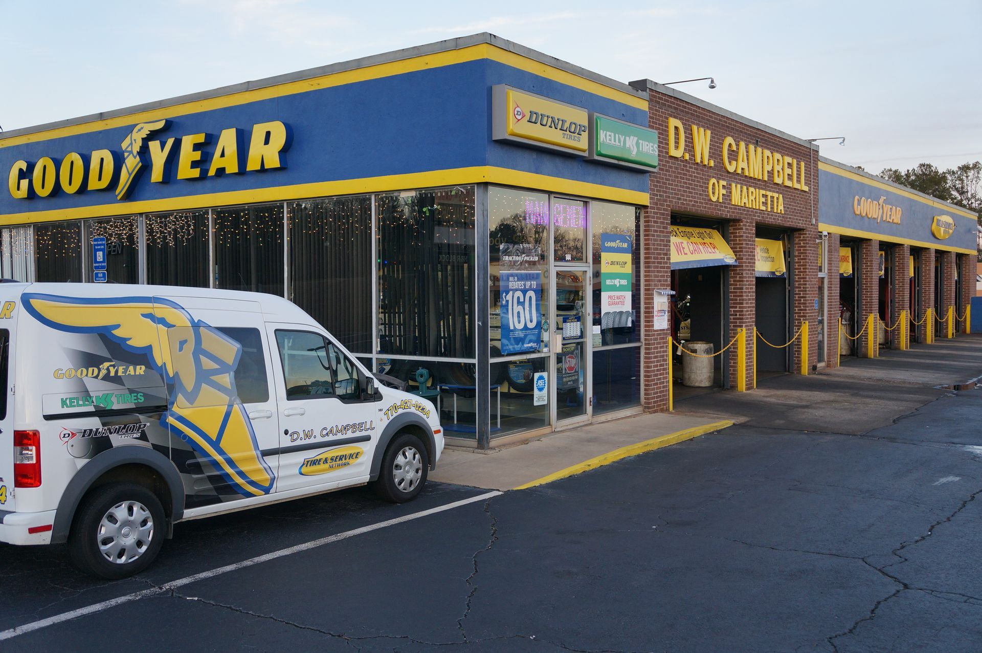 D.W. Campbell Tire shop, blue and yellow building, white van with Goodyear logo, parking lot.