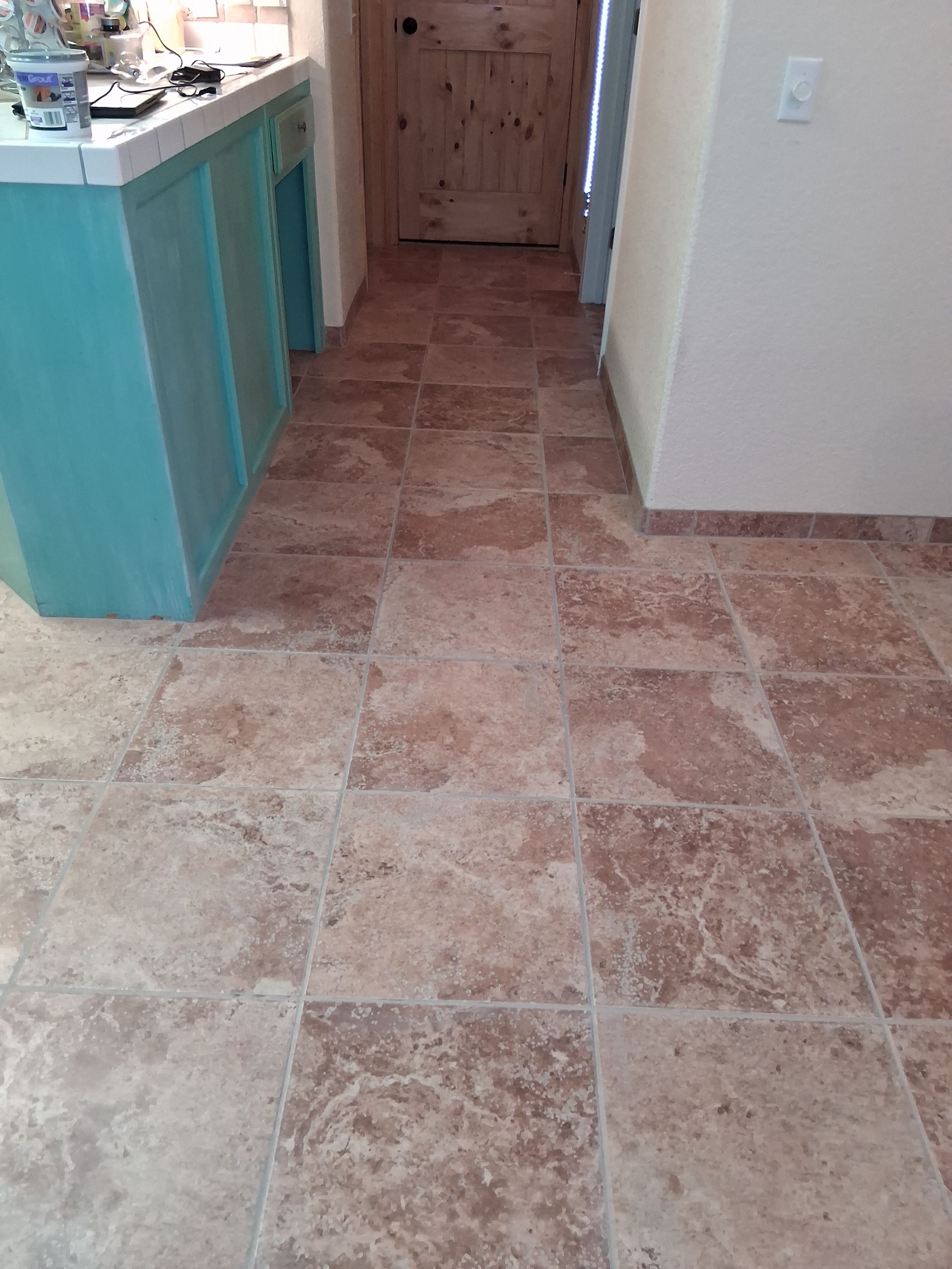 A close up of a tiled floor with white grout.
