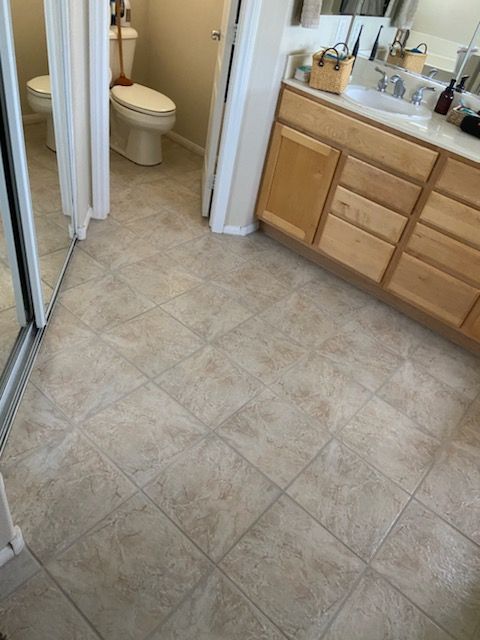 A bathroom with a toilet , sink and mirror.