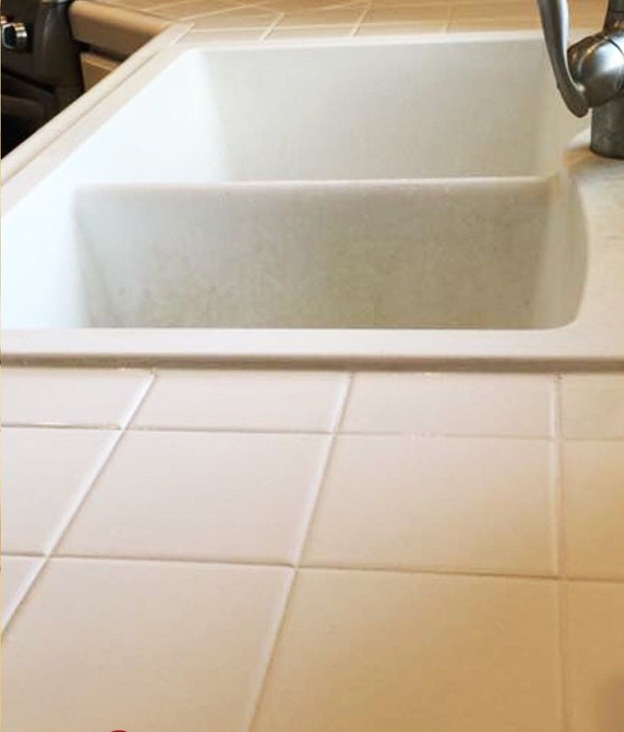 A kitchen sink with a faucet on top of it