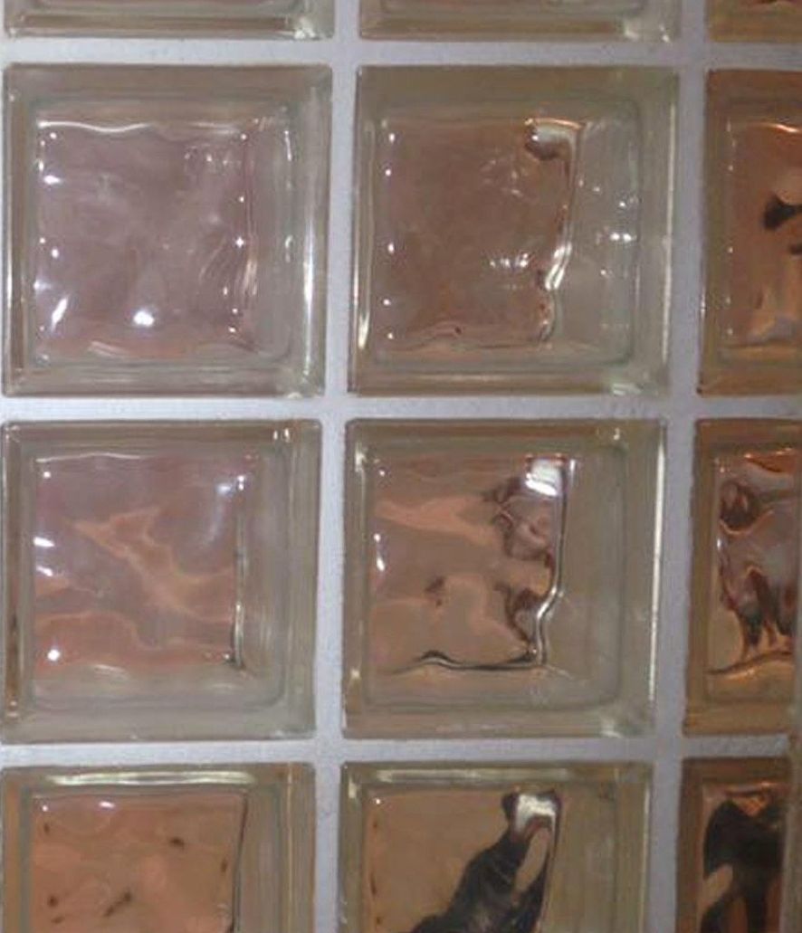 A row of clear glass blocks on a white wall.