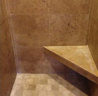 There is a corner bench in the shower.