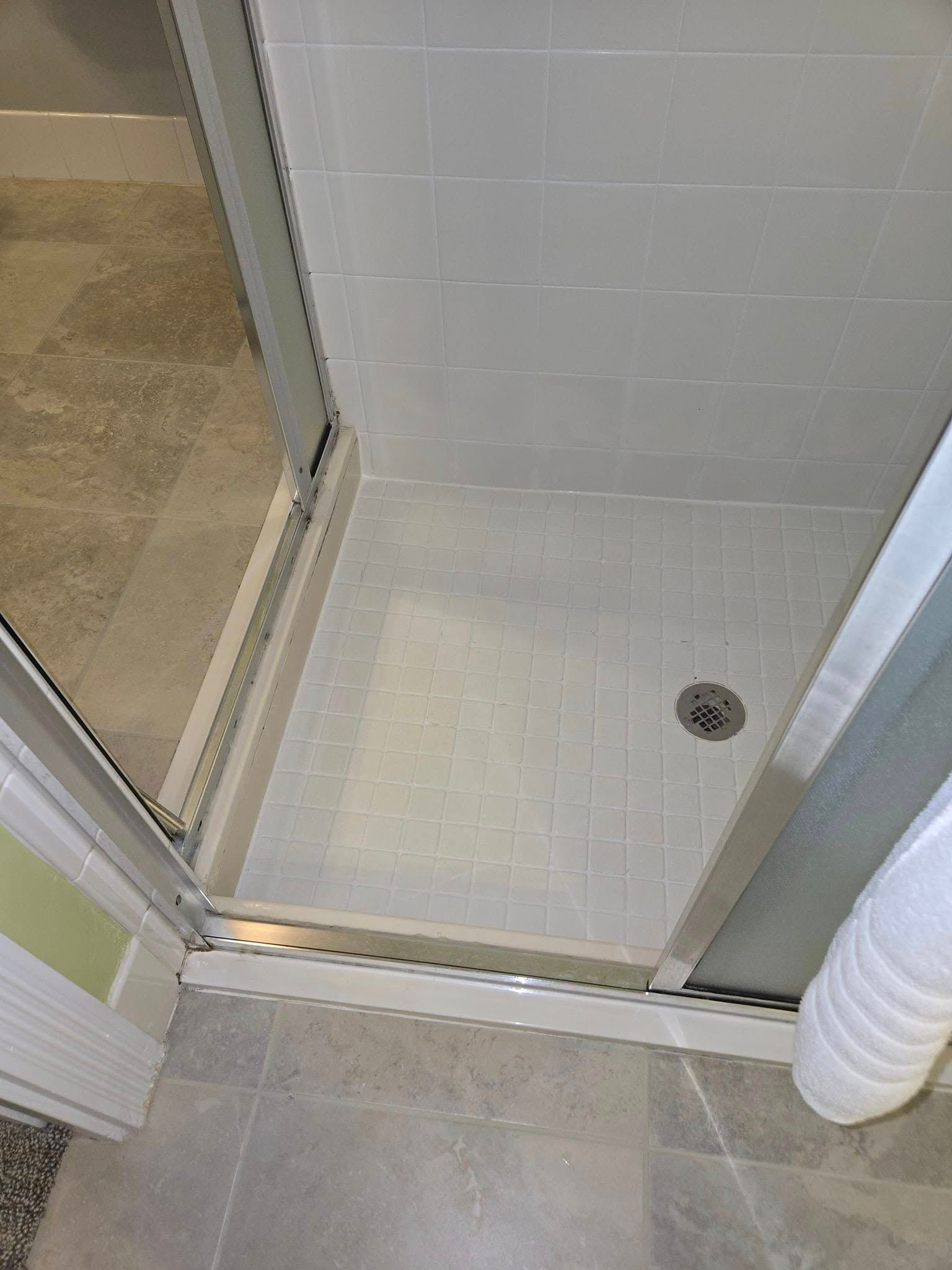A bathroom with a walk in shower with a glass door.
