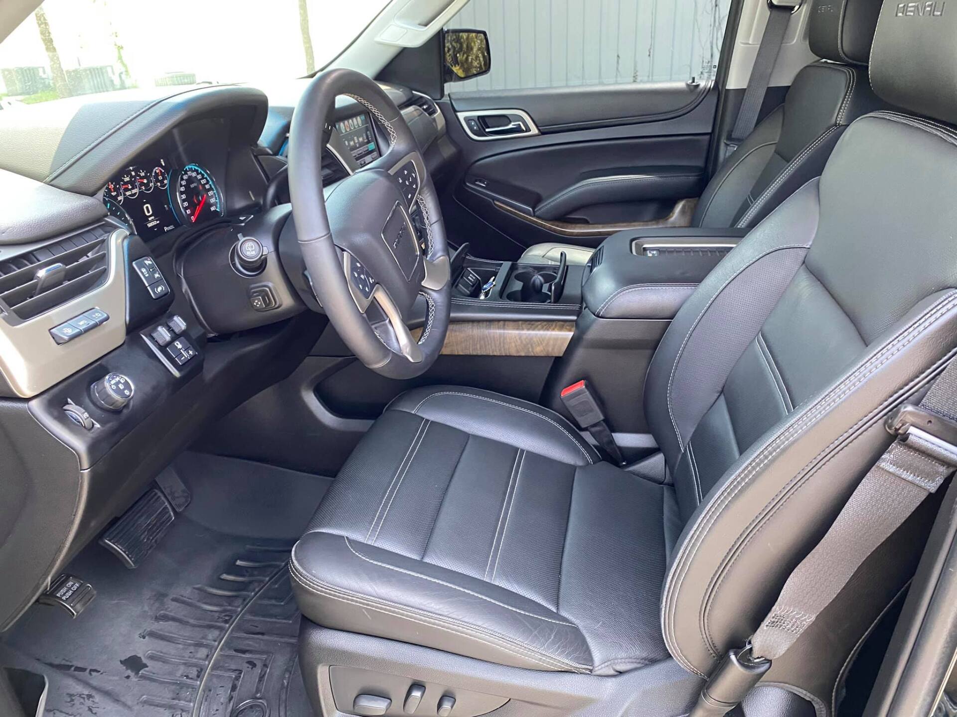 Black leather interior of a GMC Yukon, with dashboard, steering wheel, seats, and center console.