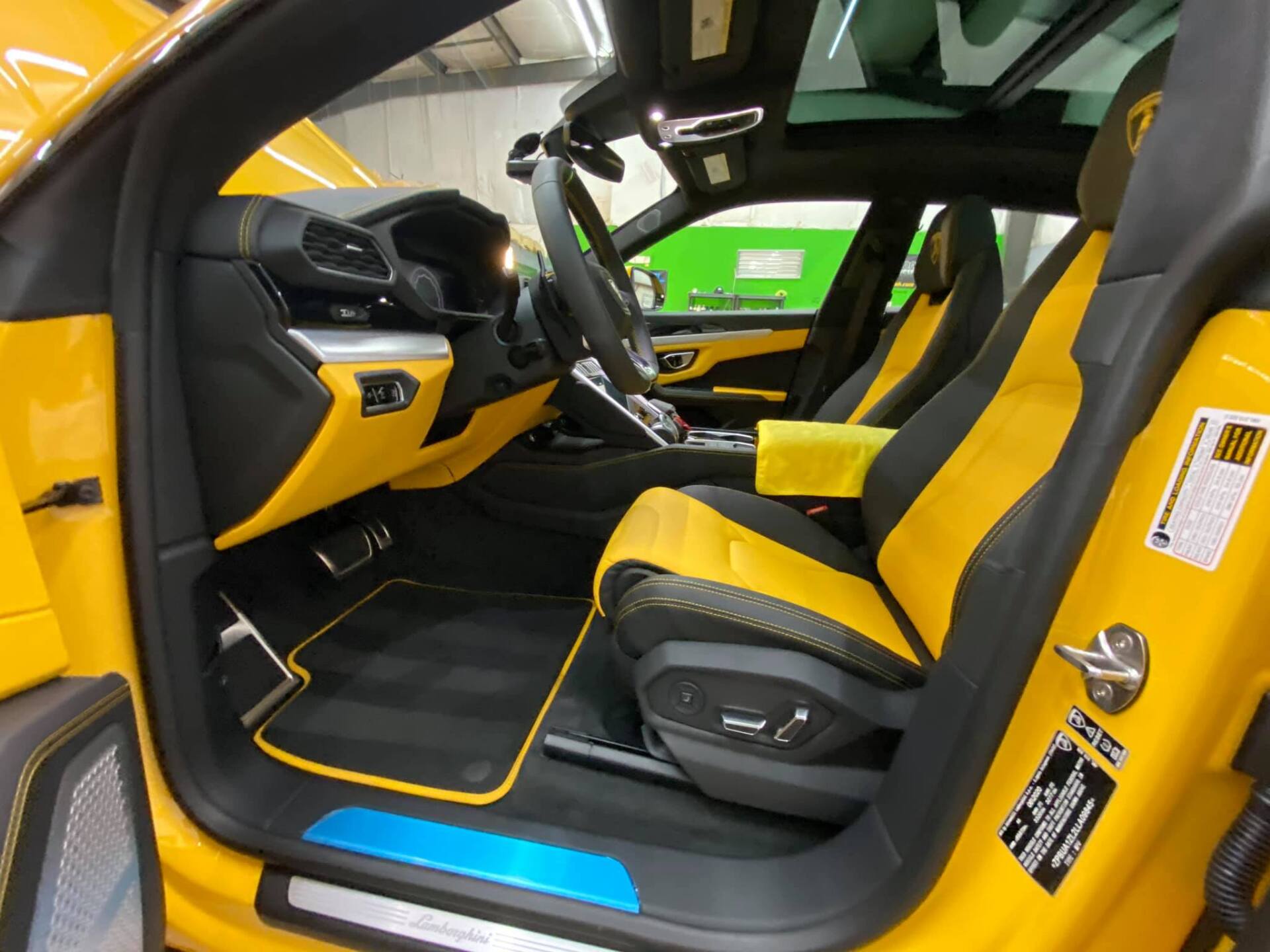 Yellow and black Lamborghini Urus interior with yellow seats and trim, blue door sill.