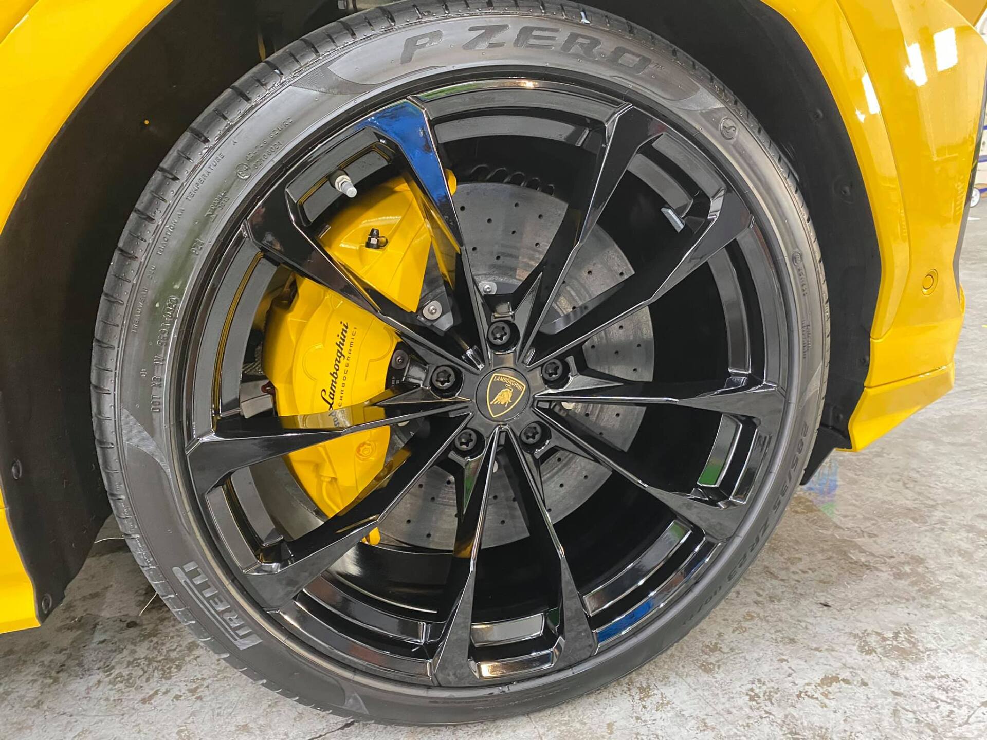 Yellow Lamborghini wheel with black rim, Pirelli tire, and yellow brake caliper.