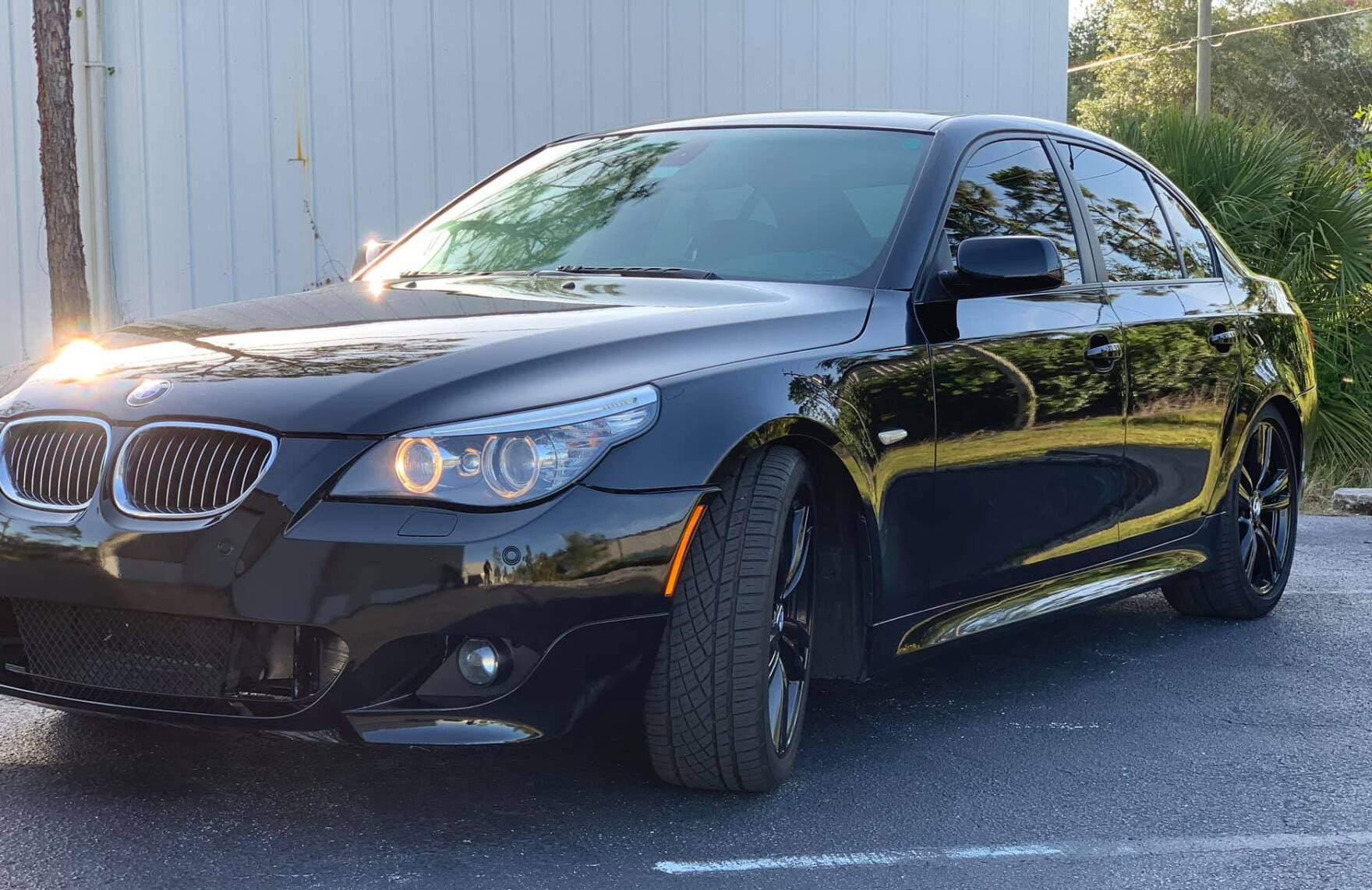 Black BMW 5-series sedan parked outside, facing the camera.