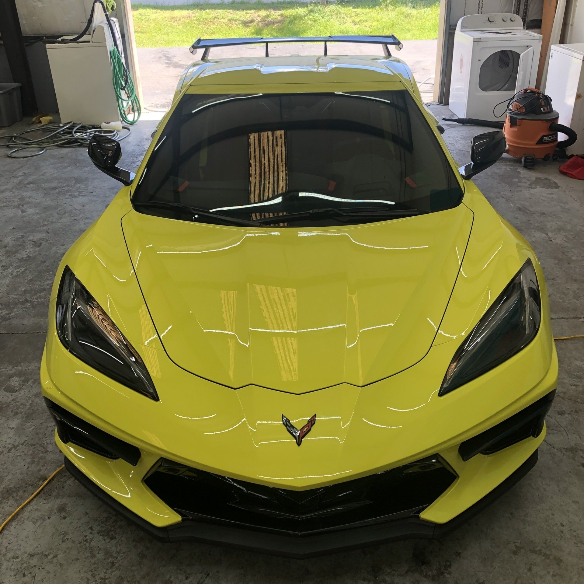 Yellow Corvette sports car parked in a garage.