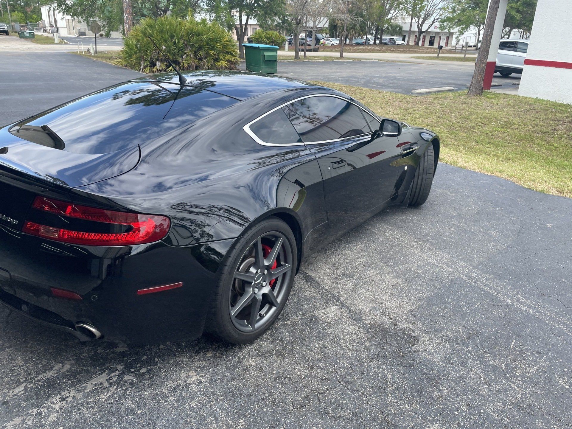 Black Aston Martin sports car parked on asphalt.