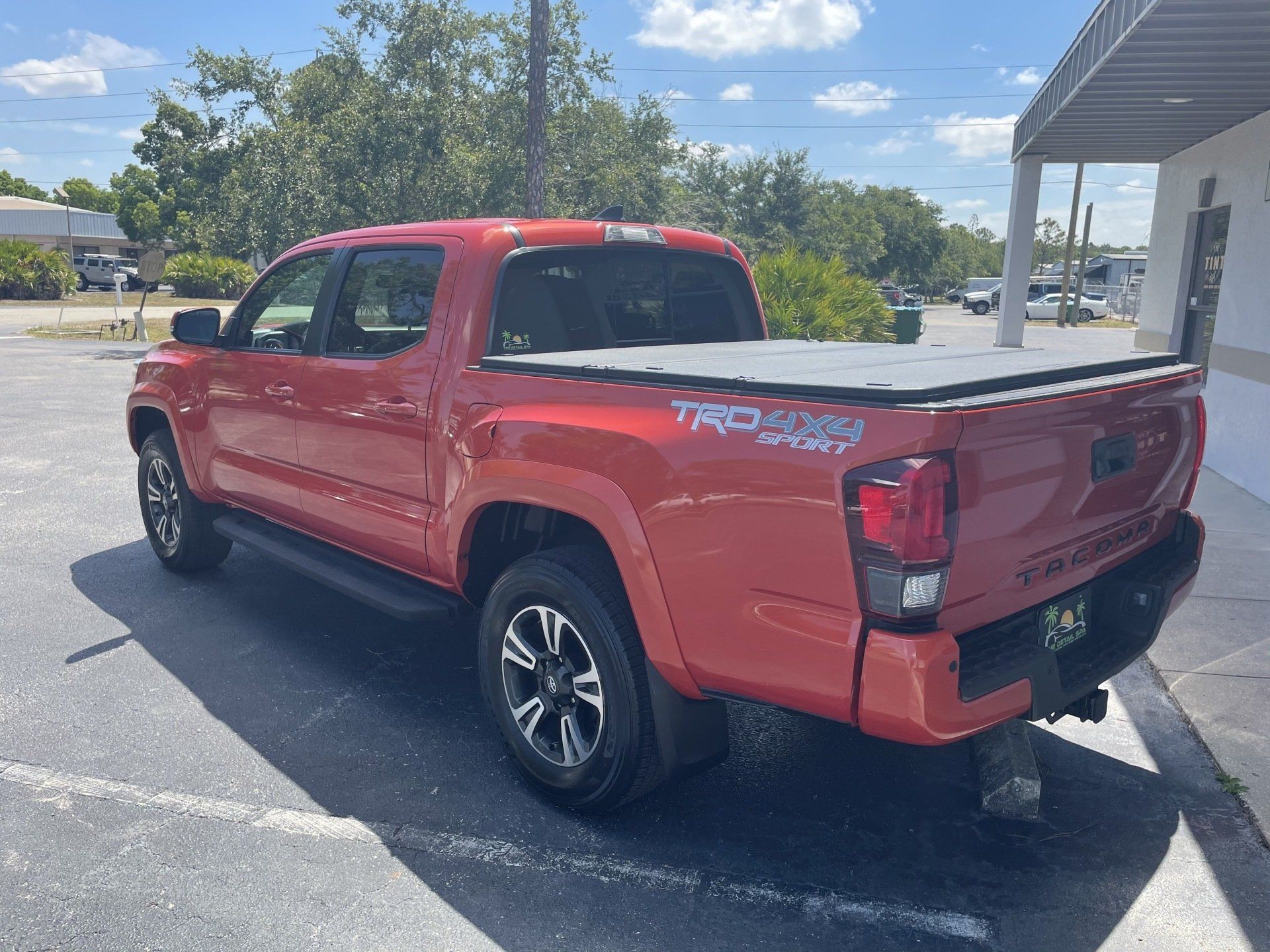 Red Toyota Tacoma truck parked outdoors.