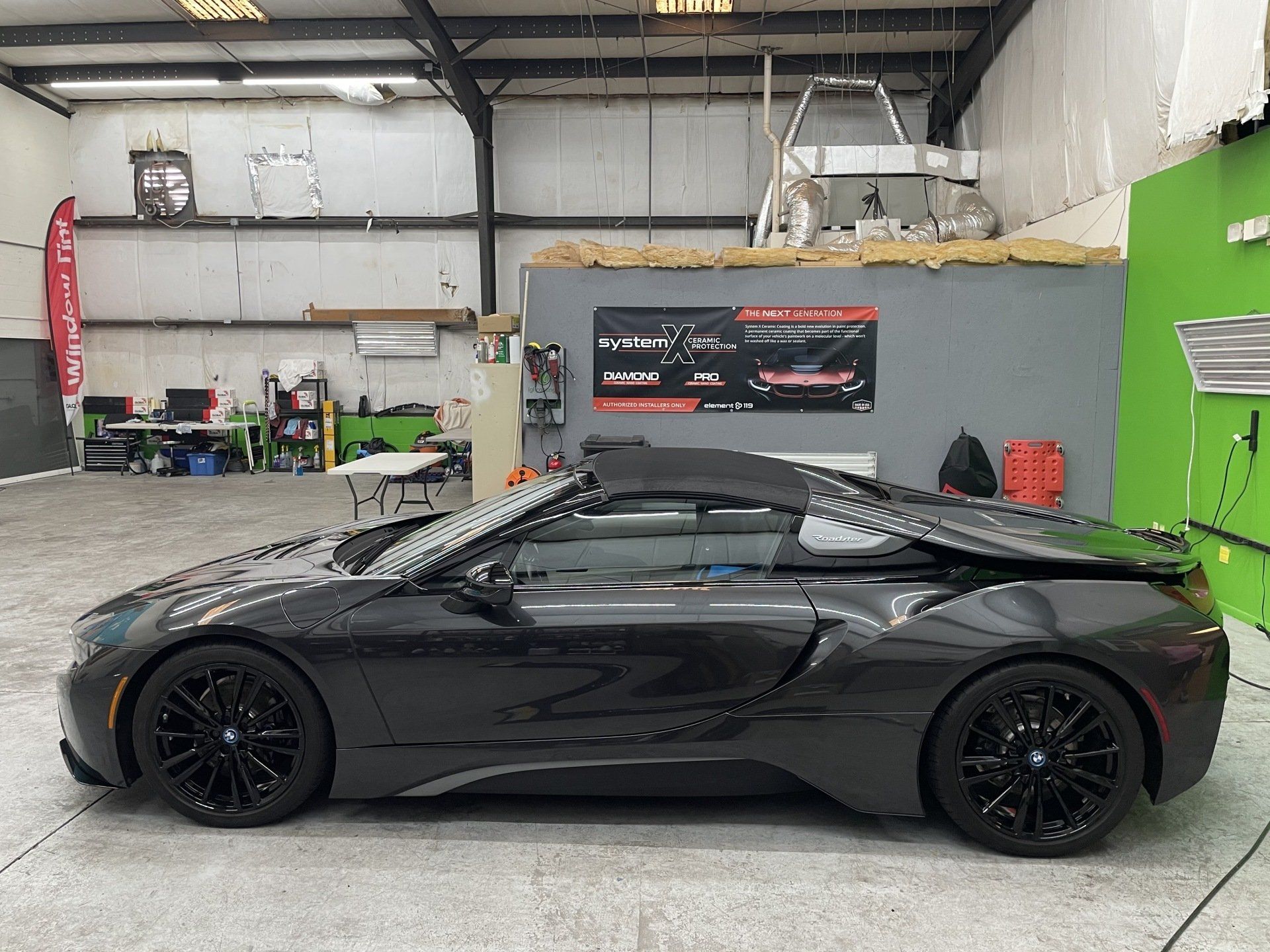 Black convertible BMW i8 inside a garage.