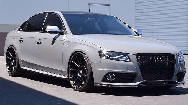 Gray Audi sedan with black wheels, parked outside.