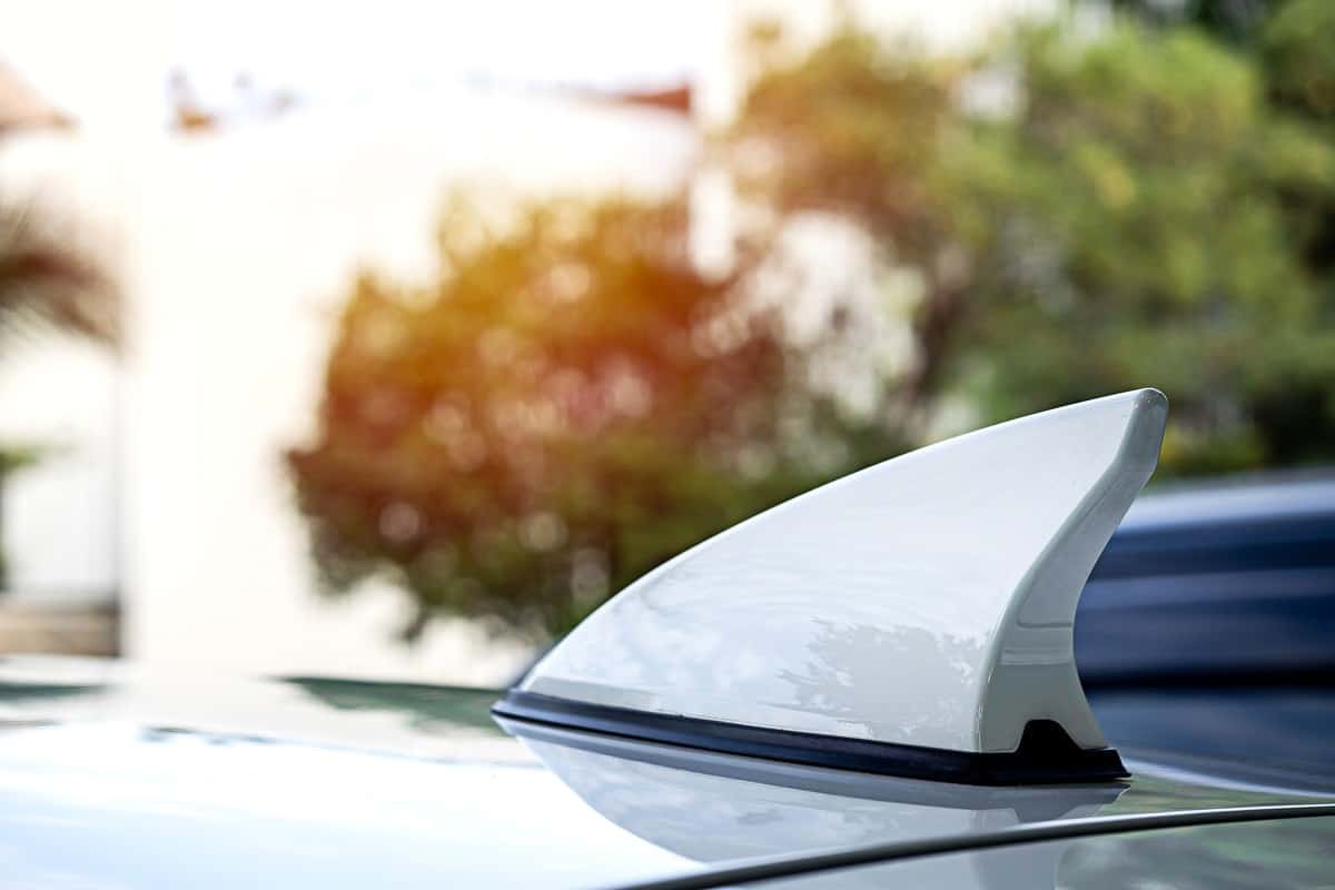 White shark fin antenna on car roof.