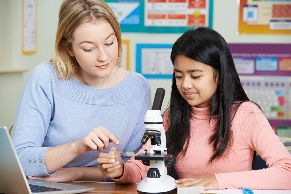 Tutor With Female Student Using Microscope — Academic & Music Tutors in Newcastle NSW