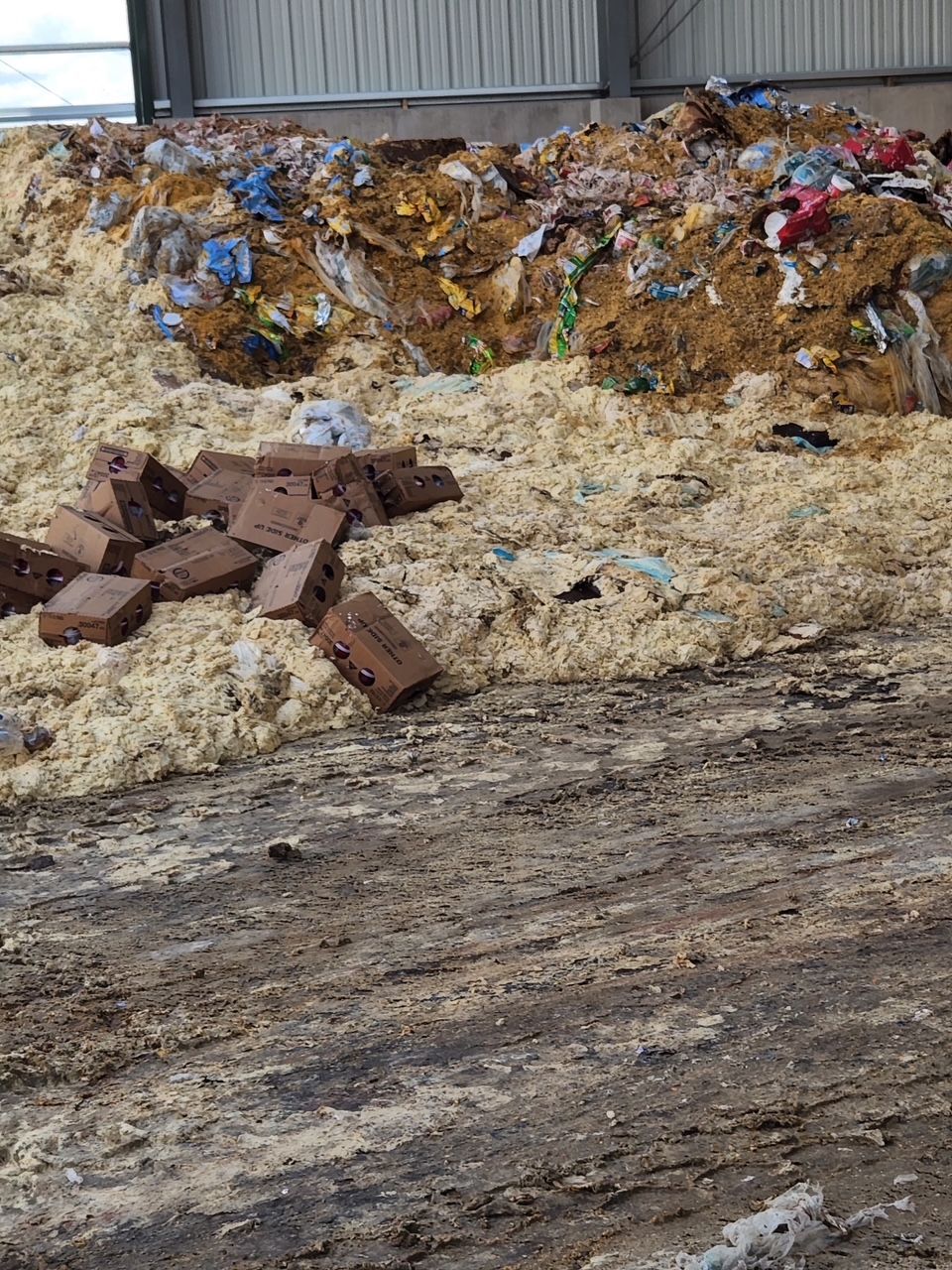 A pile of trash is sitting on the ground in a warehouse. — Monroe Township, NJ — Slammin Canz, Inc.