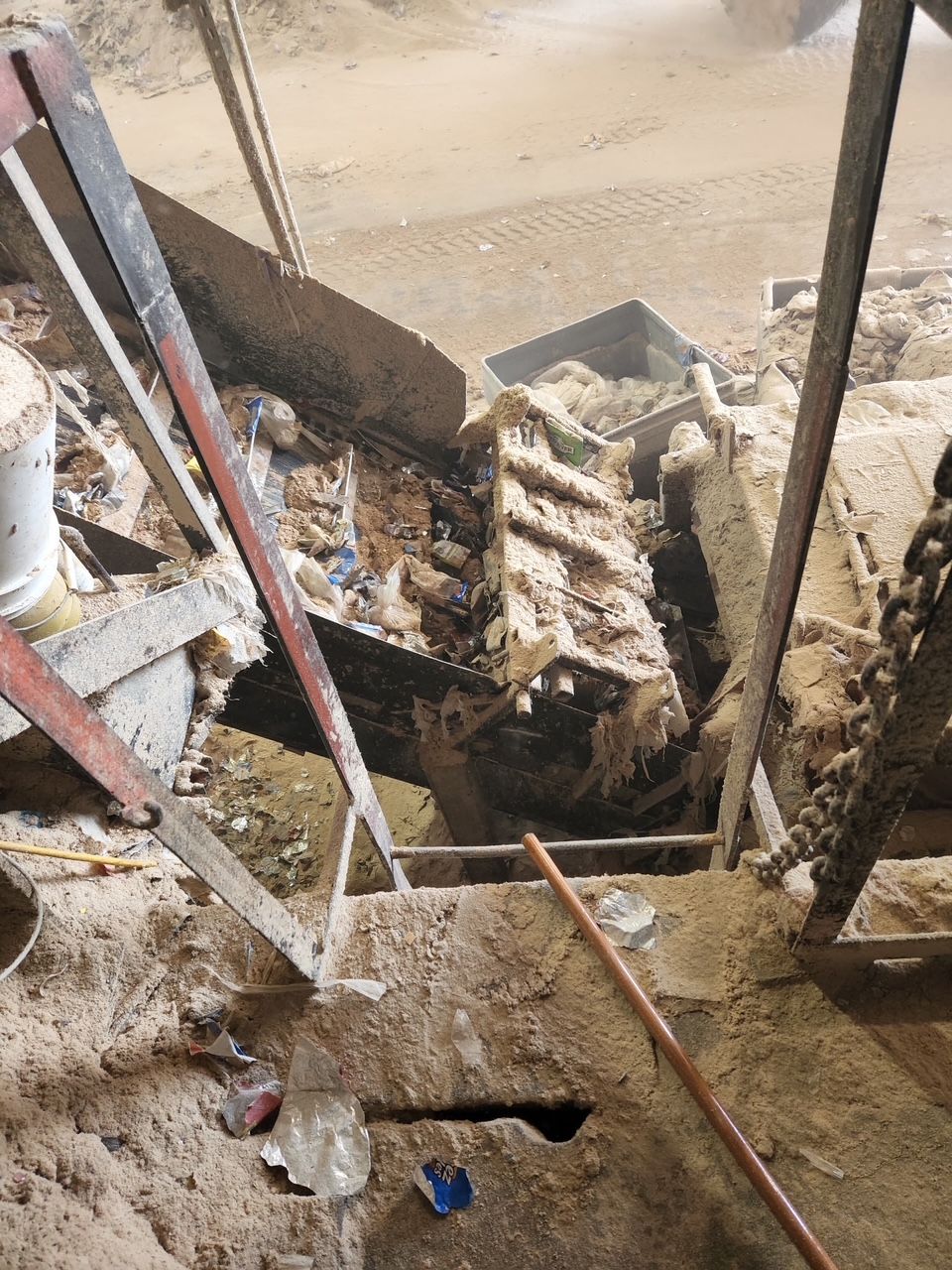 A ladder is sitting on top of a pile of dirt. 