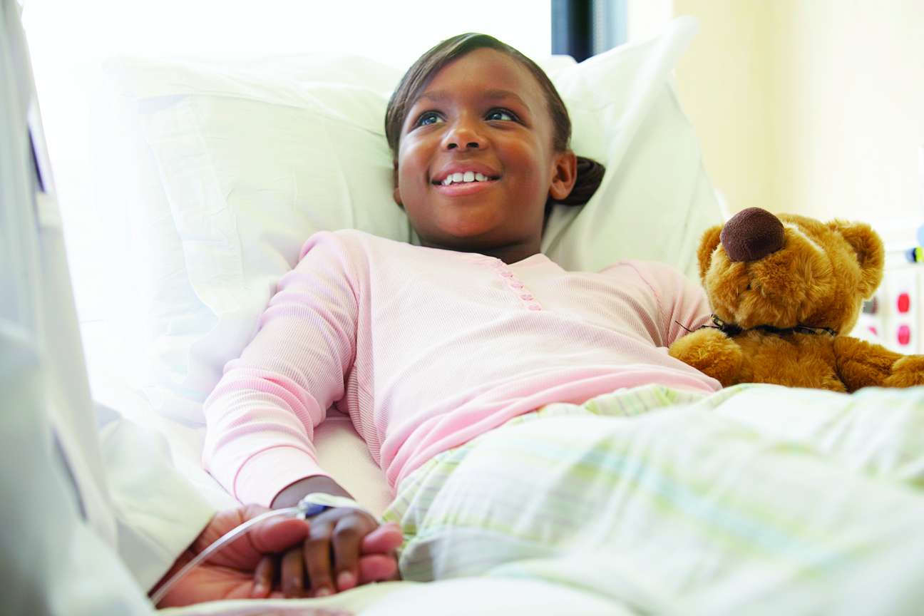 Little Girl in Bed Smiling With Teddy Bear