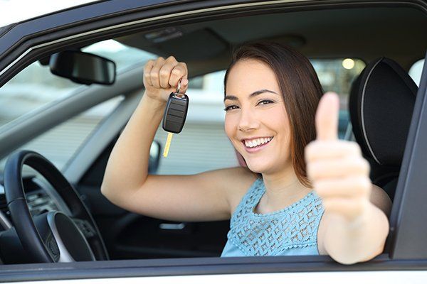 Happy Car Owner with A Key and Thumbs Up — Chicago, IL — Illinois Insurance Center Inc