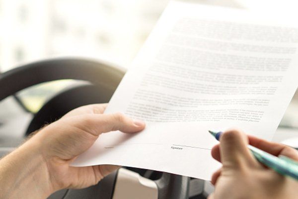 Man Signing Motor Vehicle Insurance Agreement — Chicago, IL — Illinois Insurance Center Inc