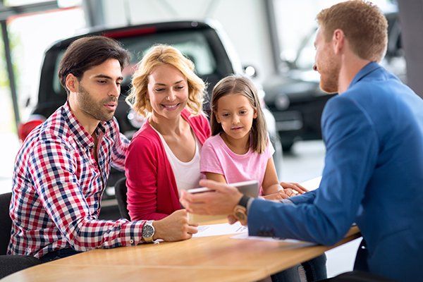Smiling Young Family with Car Dealer — Chicago, IL — Illinois Insurance Center Inc