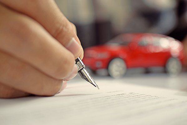 Man Signing Car Insurance Document — Chicago, IL — Illinois Insurance Center Inc