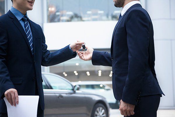 Car Salesman Handing Over the Keys for a New Car — Chicago, IL — Illinois Insurance Center Inc