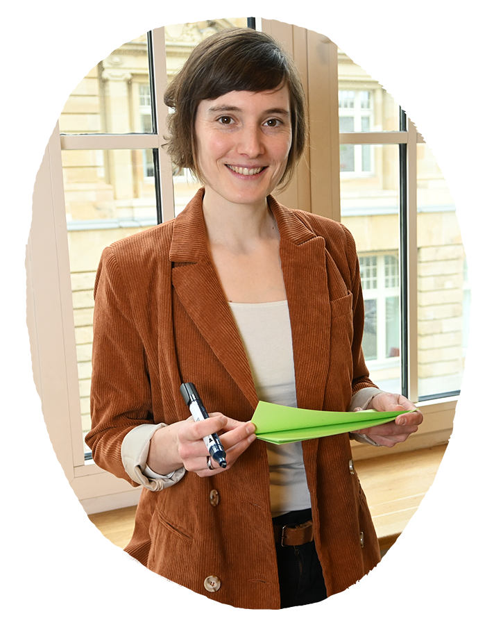 Eine Frau hält Moderationskarten und einen Stift