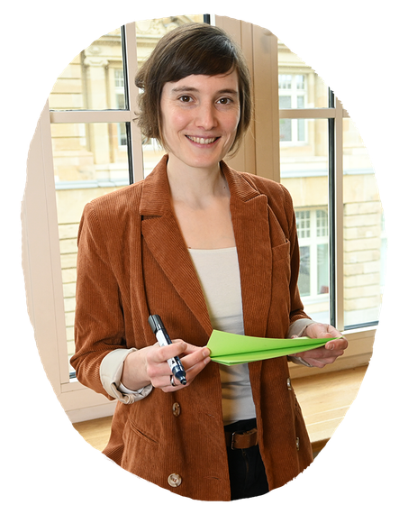 Eine Frau hält Moderationskarten und einen Stift