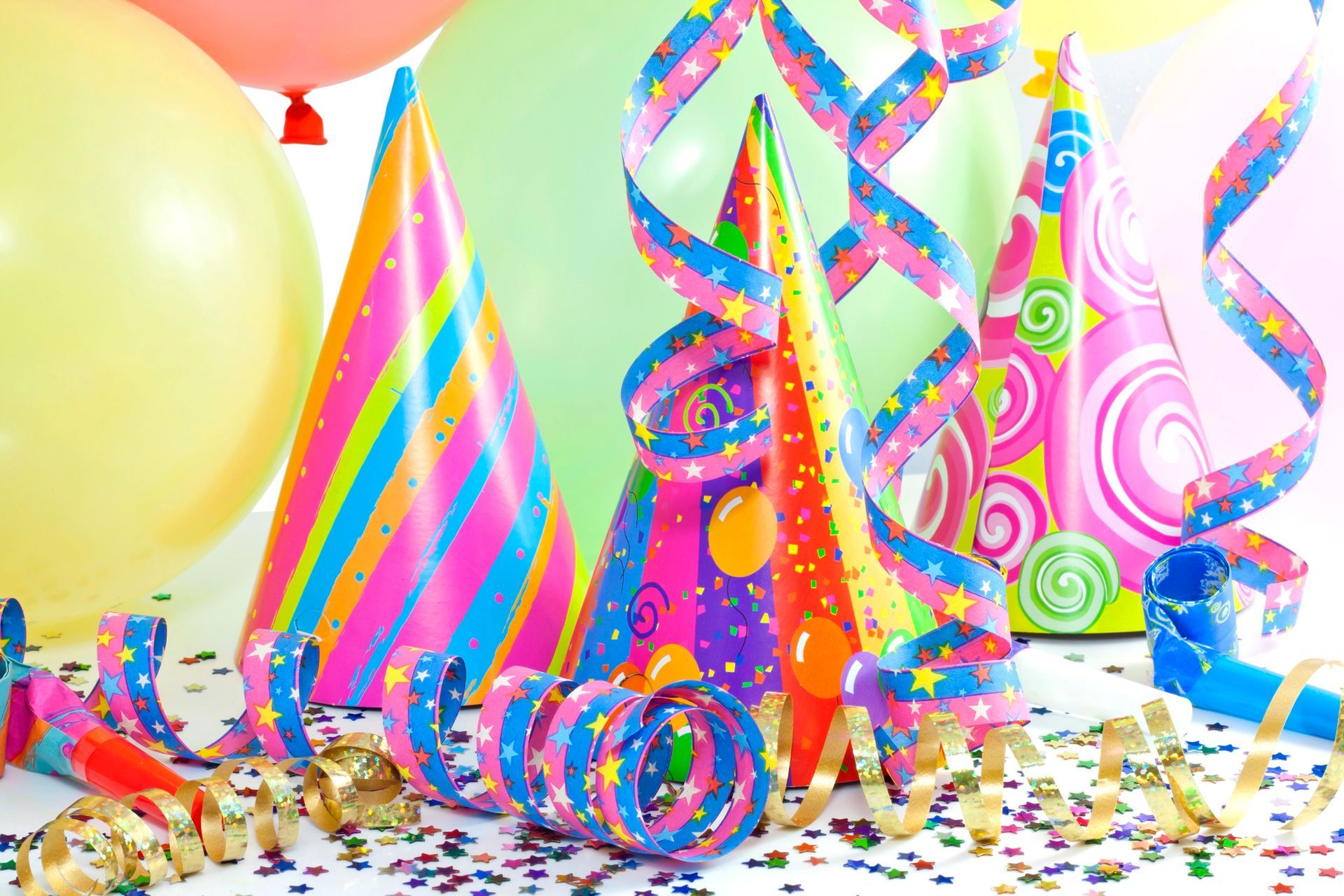 Sombreros de fiesta, globos y serpentinas, celebrando una reunión festiva con confeti.