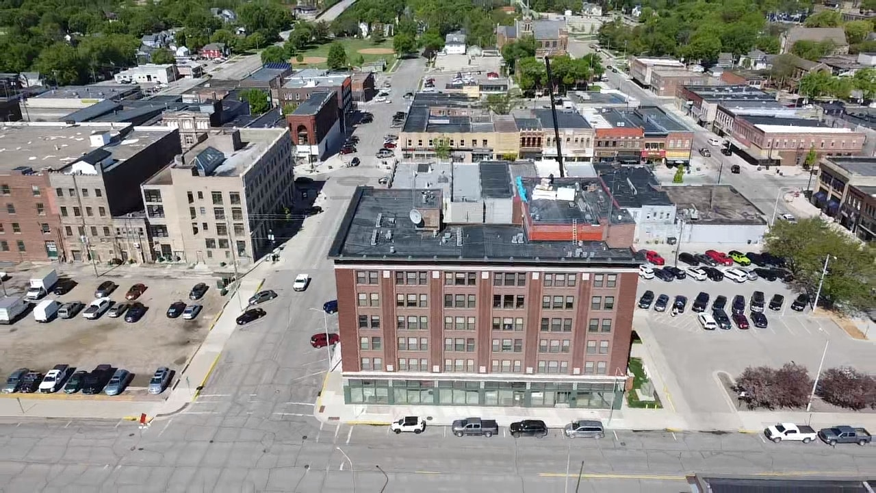 An aerial view of a city with a large brick building in the middle